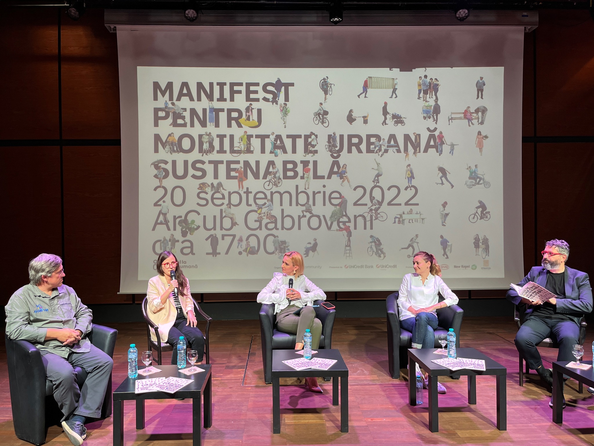 5 members of the panel, including myself, on stage. I have the mic and I am speaking.